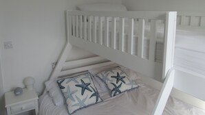 A bunk bed with white bedding and starfish-patterned pillows. - 8 Harlyn Mews (Padstow)