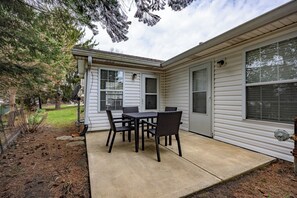 A covered patio with a table and chairs, a door, and windows. - Keystone Garden Villa C (Indianapolis)