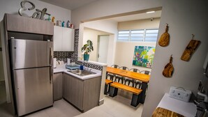 Una cucina moderna con frigorifero in acciaio inossidabile, lavello e panche in legno.