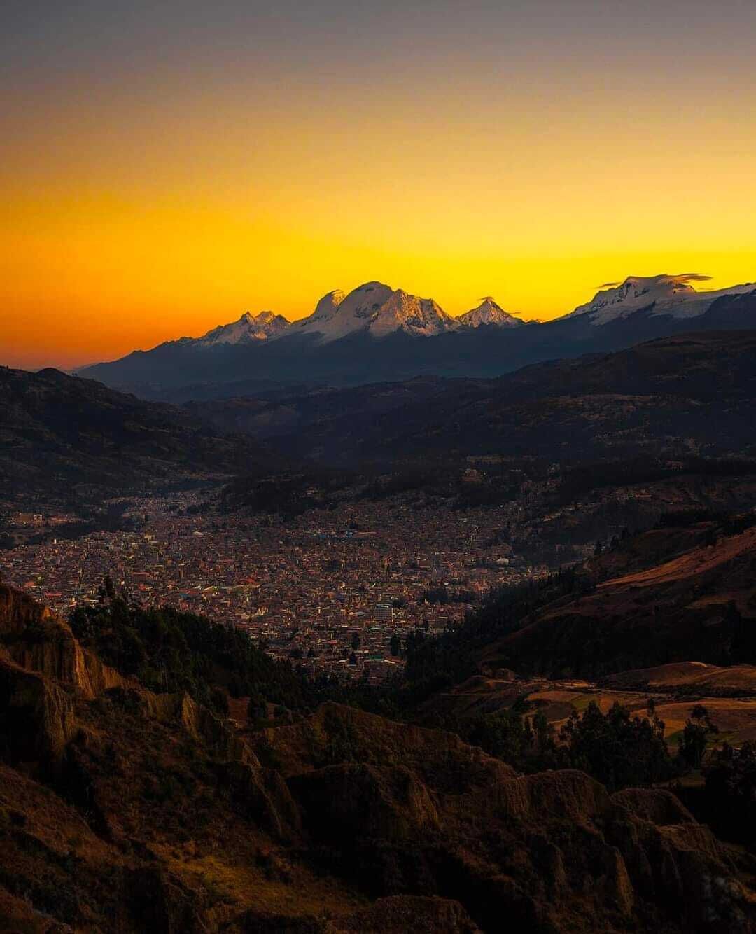 Un paisaje montañoso con una ciudad en el valle.