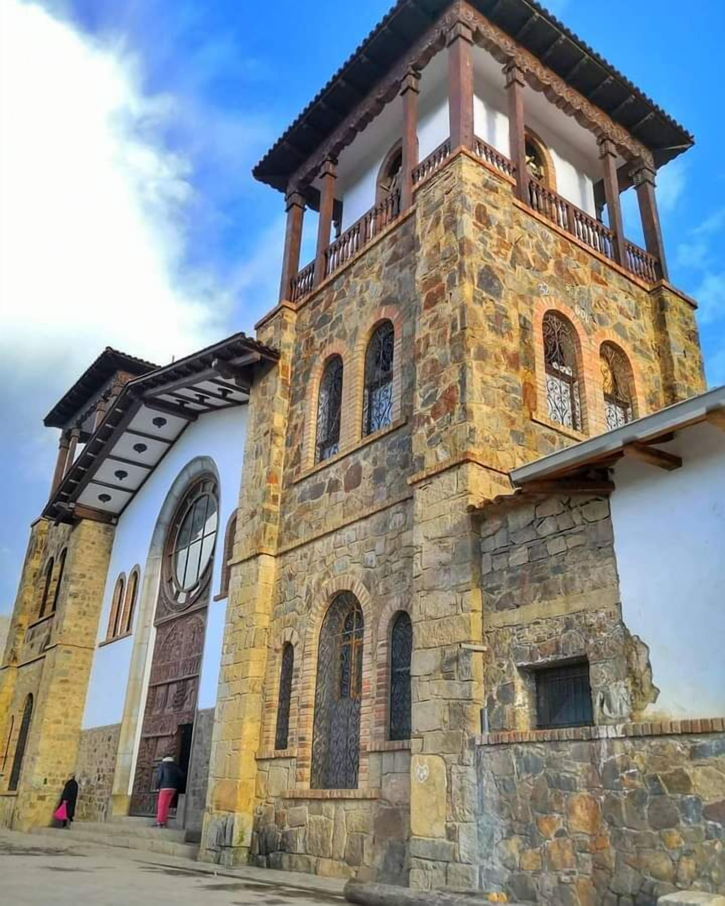 A historic stone building with a bell tower, arched windows, and a balcony.