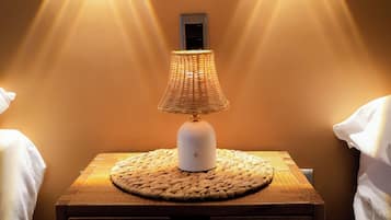 A nightstand with a lamp and two wall-mounted lights.