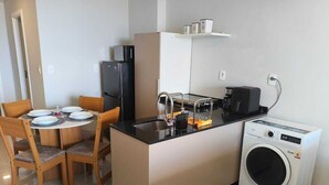 Una cocina compacta con comedor, lavadora y refrigerador.