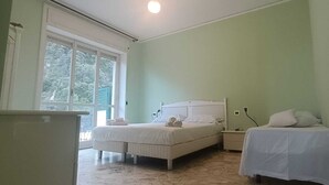 Quarto com cama, mesas de cabeceira e janela.