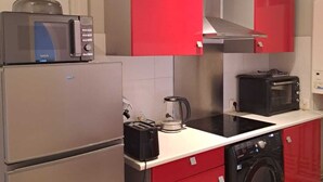 A compact kitchen with a microwave, toaster, kettle, and washing machine. - Appart l'Elégant in the historic center of Saumur (Saumur)