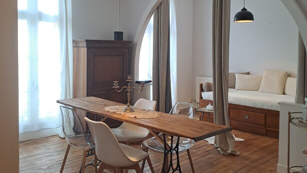 A dining area with a wooden table, chairs, and pendant lights. - Appart l'Elégant in the historic center of Saumur (Saumur)