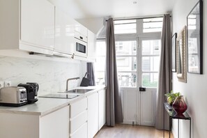 Eine moderne Küche mit weißen Schränken, einer eingebauten Mikrowelle, einem Toaster und einem Spülbecken.
