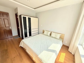 A bedroom with a bed, wardrobe, and a door. - HOMESTAY SKYCENTER 2 PHONG NGU (ho Chi Minh)