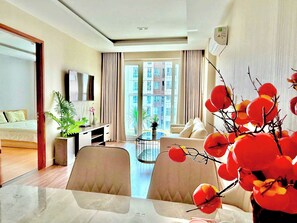 A modern hotel room with a bed, a desk, a dining area, and a large window with a city view. - HOMESTAY SKYCENTER 2 PHONG NGU (Ho Chi Minh City)