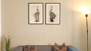 A grey sofa with two brown cushions, a framed picture on the wall, and a floor lamp. - Santa Cruz Holiday Home (Santa Cruz de Tenerife)