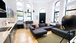 Una cocina moderna con comedor, un conjunto de sofás y ventanas amplias.