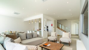 Una sala moderna con un sofá, sillones y una mesa de centro.