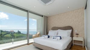 Un dormitorio moderno con una cama grande, una mesita de noche y vistas al paisaje.