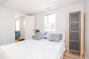 A bedroom with a bed, pillows, a window, and a door. - Cute Newly Remodeled Home Close to Notredame 2bed (Mishawaka)