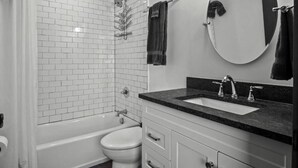 Un baño moderno con bañera, inodoro y lavamanos.