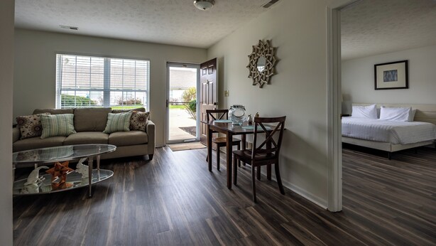 A spacious living area with a sofa, dining table, and a bed. - Keystone Garden Villa B (Indianapolis)