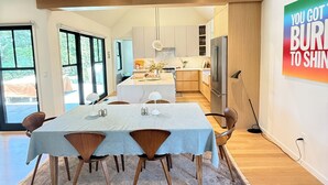 Una cucina moderna con un'isola centrale, mobili in legno e un'area pranzo con tavolo e sedie.