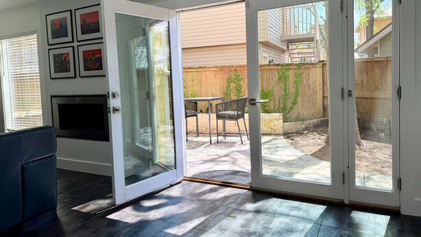 A modern interior with a sliding glass door leading to an outdoor patio area. - King William Historic District Cozy 3BR SATX (San Antonio)