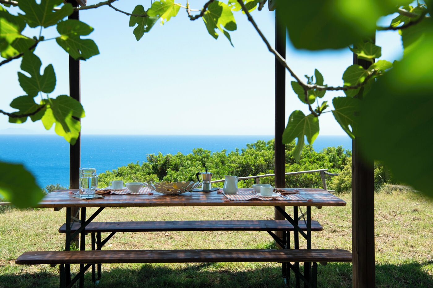 A picnic table set up outdoors with a view of the ocean.