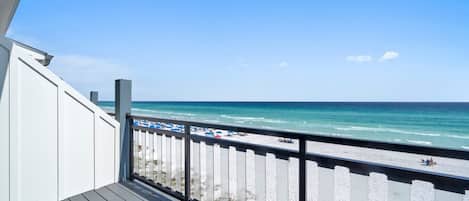 A balcony with a view of a beach and ocean.