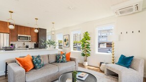 Ein modernes Wohnzimmer mit einem grauen Sofa, einem runden Couchtisch und einem kleinen Beistelltisch.