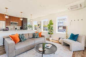 A modern living room with a grey sofa, a round coffee table, and a small side table.
