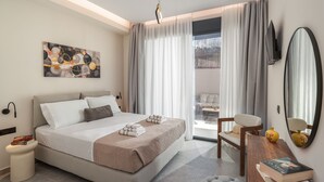 Moderni hotellihuone, jossa on sänky, työpöytä, tuoli, televisio ja suuri ikkuna, jossa on verhot.