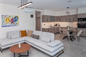 Un salon moderne avec un canapé, une table basse et un coin repas.