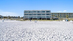 A beachfront hotel with multiple balconies, a sandy beach in front, and a clear sky. - Beachfront | Top-Rated | Sleeps 10 | Seabatical #3 (Destin)