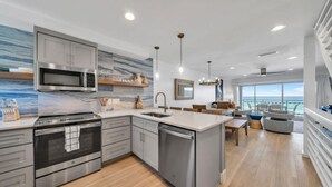 A modern kitchen with a central island, built-in appliances, and a view to the sea. - Beachfront | Top-Rated | Sleeps 10 | Seabatical #3 (Destin)