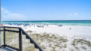 A beach with umbrellas and lounge chairs, a clear sky, and a view of the ocean. - Beachfront | Top-Rated | Sleeps 10 | Seabatical #3 (Destin)