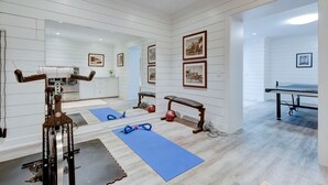 A spacious room with a ping pong table, exercise equipment, and framed pictures on the walls. - EAST HAMPTON VILLAGE JEWEL BOX (East Hampton)