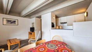 A compact room with a bed, a small table, a chair, a TV, a kitchenette, and a door leading to another room. - 100m from resort center, 8th floor, balcony, tv, 45m², Flaine (Flaine)