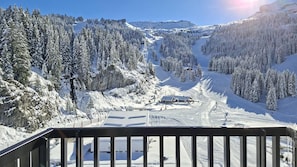 Schneebedeckte Berglandschaft mit einem Skigebiet, einschließlich Sessellift und einem Gebäude.