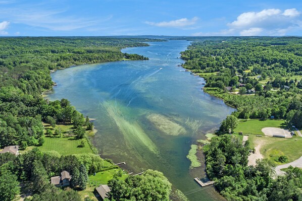 An aerial view of a river surrounded by dense forests and residential areas.