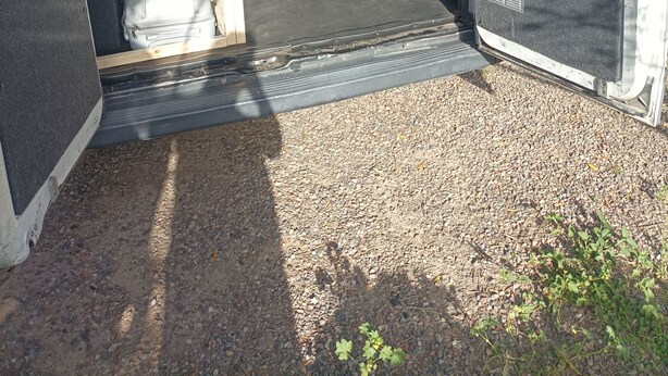 Una camioneta con una cama, una mesa, un dardo y una planta pequeña.