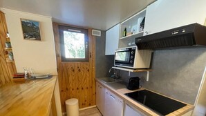 Een koffiezetapparaat/waterkoker, een koelkast, een oven, een vaatwasser