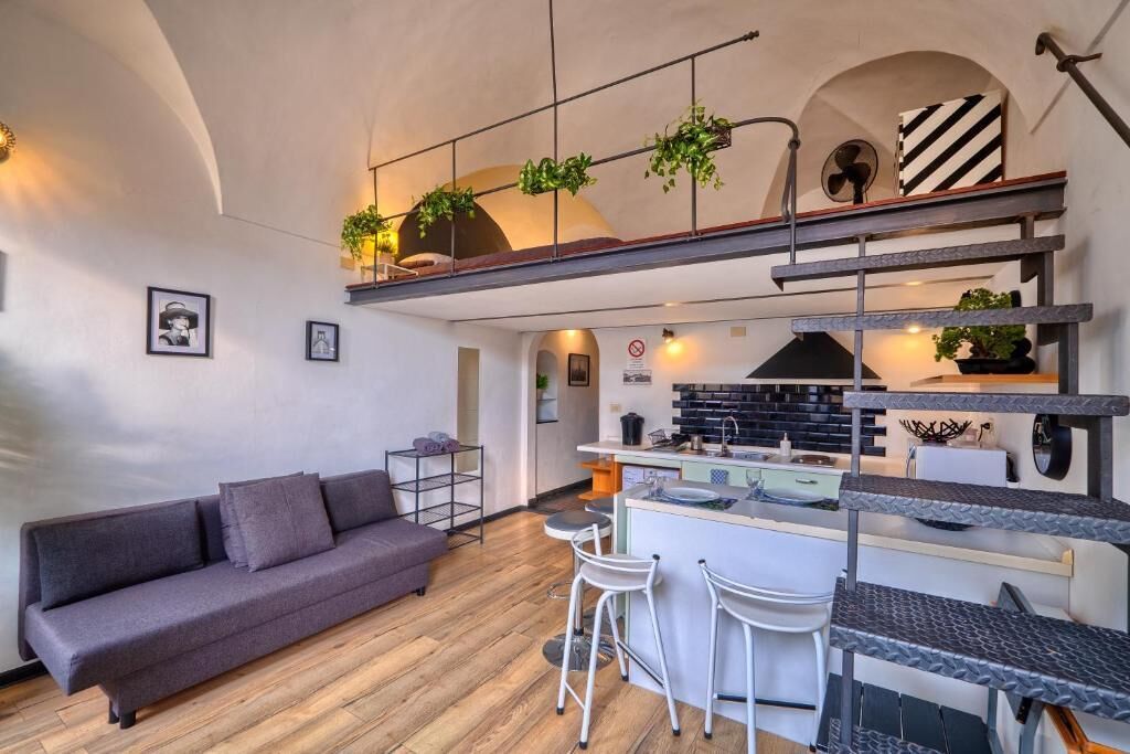 Een modern loft appartement met een bank, keuken en een barretje.