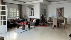 Un salon spacieux comprenant un canapé, une table basse et un coin repas avec des chaises.