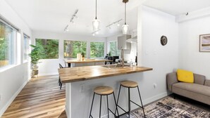 Eine moderne Küche mit einer Holztischinsel, Barhocker und Pendelleuchten.