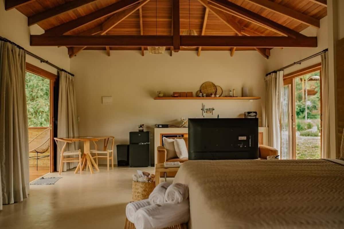 A room with a bed, a desk, a television, and a window.