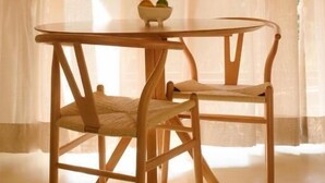 A round wooden table with two chairs, a bowl with fruits, and sheer curtains. - Canto dos Pireneus Hospedaria (Pirenopolis)