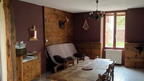 Un comedor con una mesa y sillas de madera, un aparador de madera y una ventana con vistas al exterior.