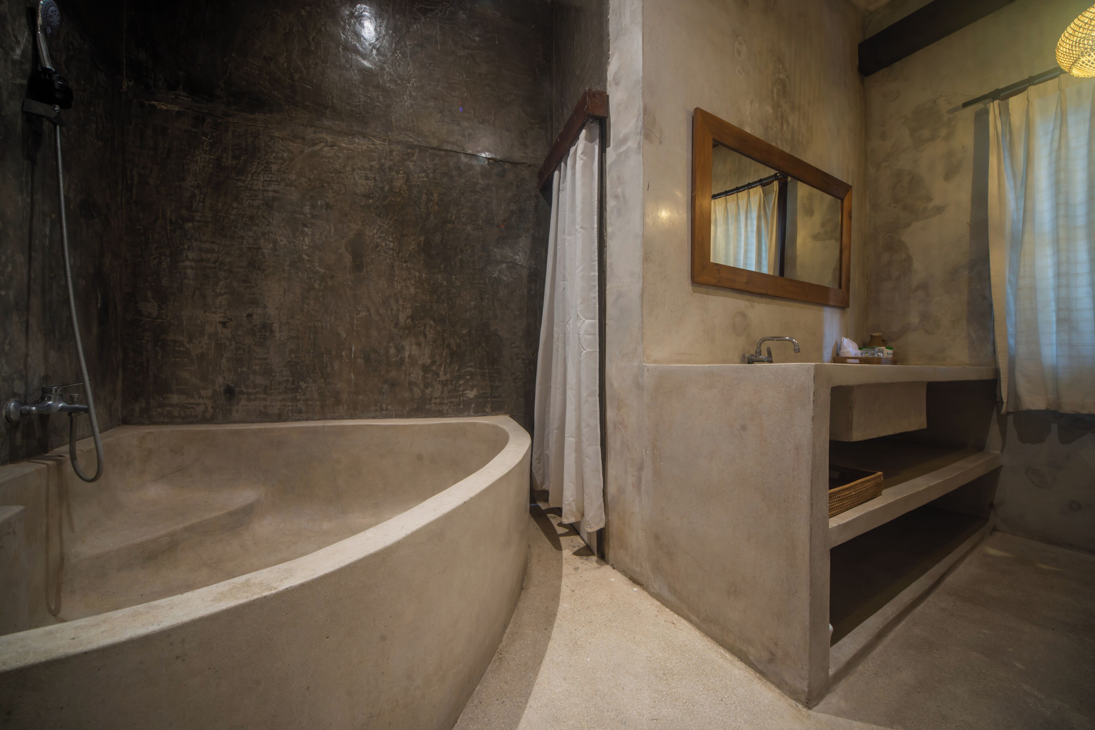 A bathroom with a freestanding bathtub, a sink, a mirror, and a showerhead.