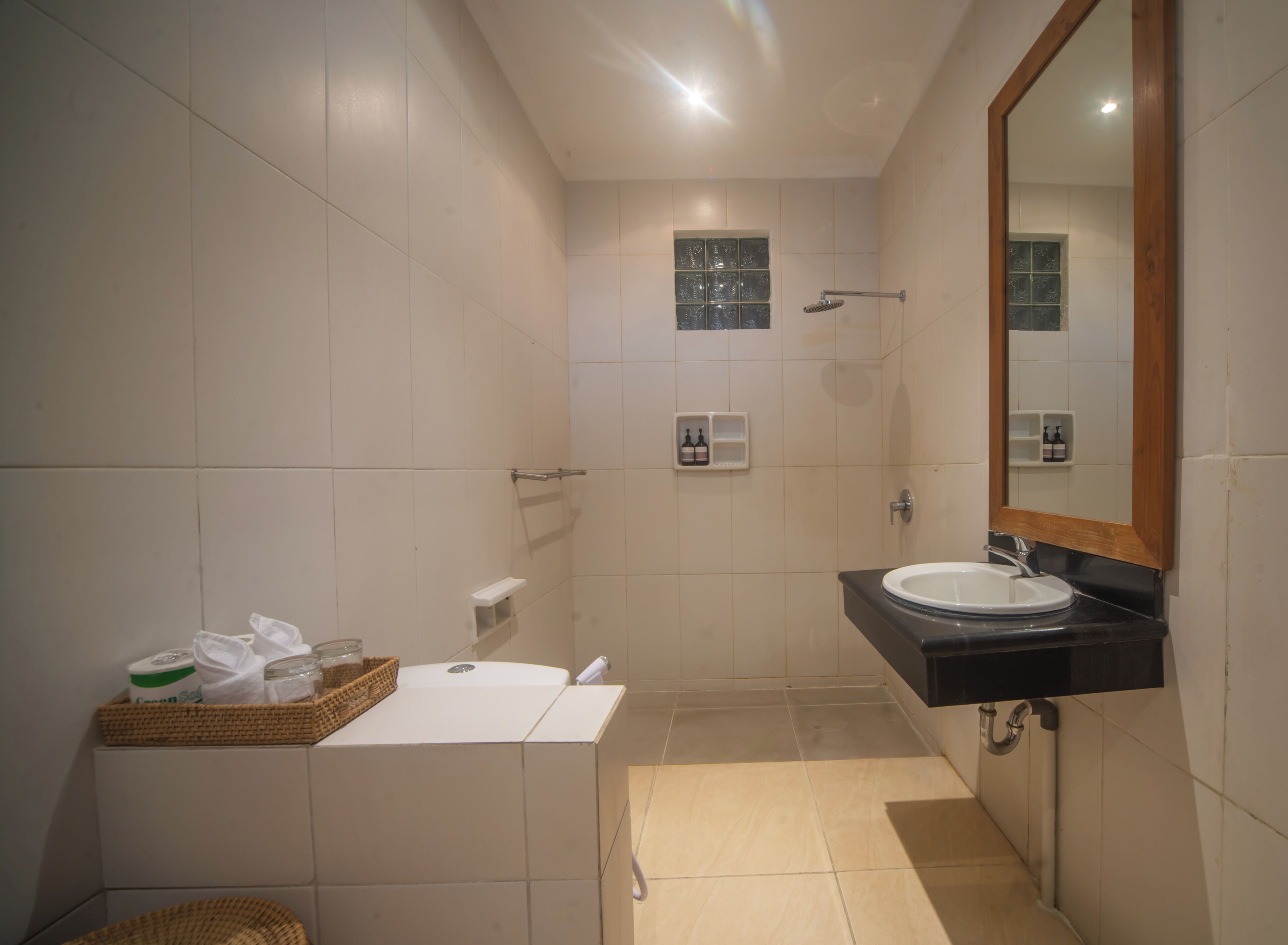 A bathroom with a white sink, a mirror, and a shower.