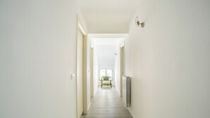 A hallway with a wooden floor, white walls, and a radiator on the right. - Elegant Lakefront Penthouse - Casa Barozzi (Luino)
