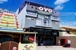 A building with a prominent 'OYO' sign, a gated entrance, and a balcony.