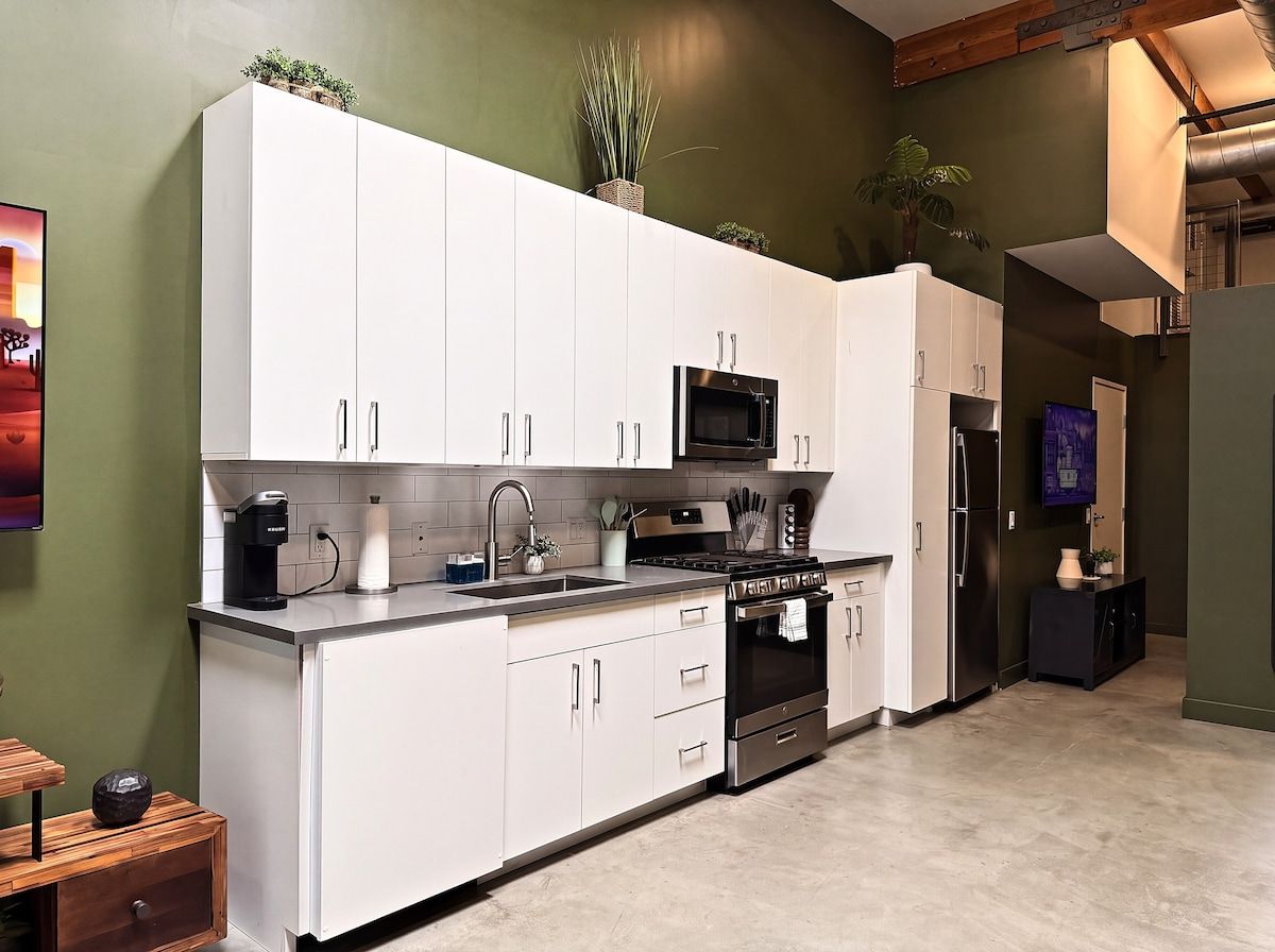A modern kitchen with white cabinets, a built-in microwave, and a stove.