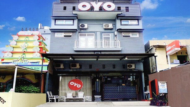 A building with a prominent 'OYO' sign, air conditioning units, and a gated entrance. - Cozy Twin Escape with Free WiFi and Parking (Banda Aceh)