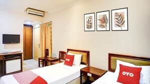A hotel room with two beds, a desk, a television, and three framed leaf artworks on the wall. - Cozy Twin Escape with Free WiFi and Parking (Banda Aceh)